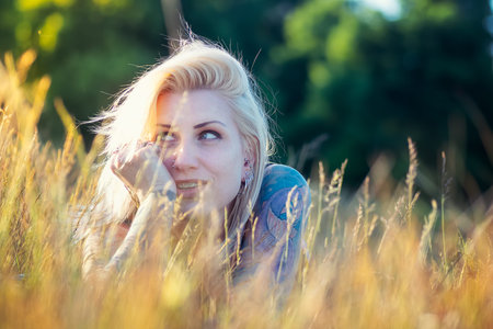 Pretty blonde woman with tattooes enjoying the sun