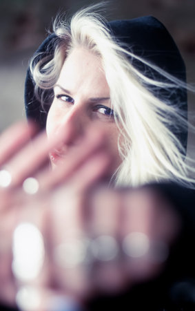 Blonde woman with hoodie throwing a punch