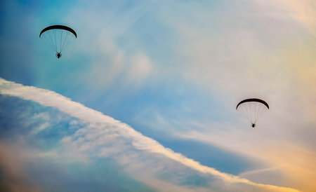 Paragliders flying into the sunset