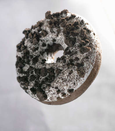 Ring donut with white icing and chocolate piecesの写真素材