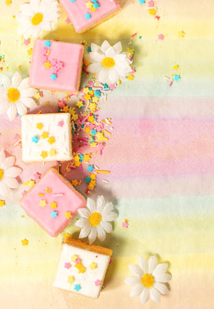 Pink and white iced cakes with sprinkles