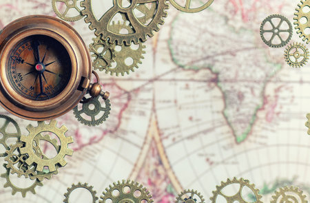 Compass with gears and cogs and an old map.の写真素材