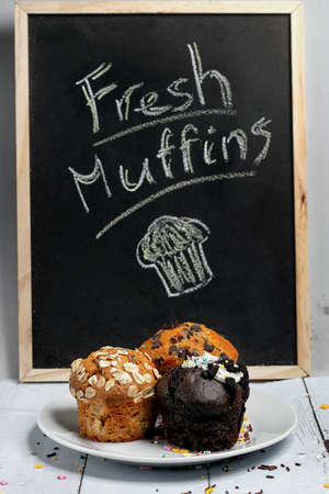 Variety of fresh muffins with a sign blackboardの写真素材