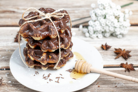 Chocolate waffles with honey on a wooden tableの写真素材