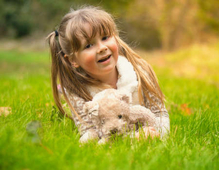 Cute little girl cuddling her teddy bearの写真素材