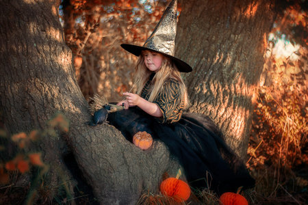 Little witch sitting on a tree in the forest