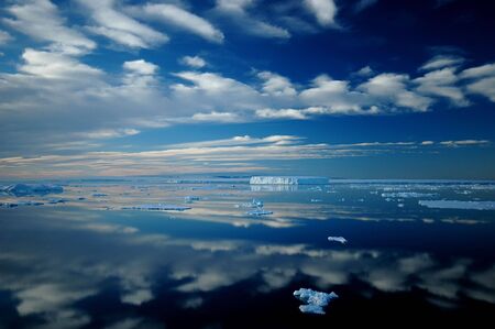 Antarctic iceberg and cloud landscape reflectingの写真素材