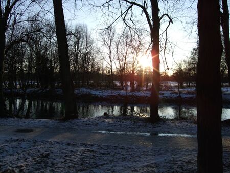 River with snowy banks and sunset in the background, Cardiff UKの写真素材