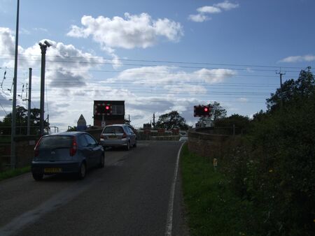 Railway level crossing with cars waitingの写真素材