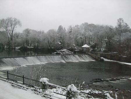 Tree stuck on a weir in winter on the River Taff, Wales, UKの写真素材