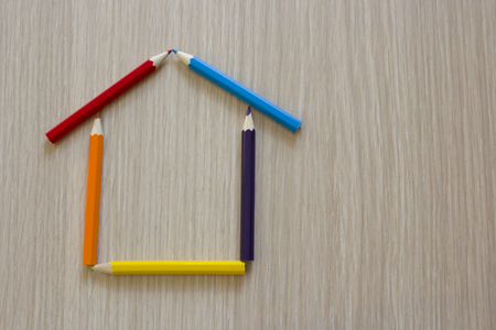 House made with colored pencils on a wooden plankの写真素材