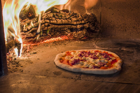 Sausage pizza in a wood ovenの写真素材