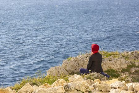 Woman doing yoga on the cliffの写真素材