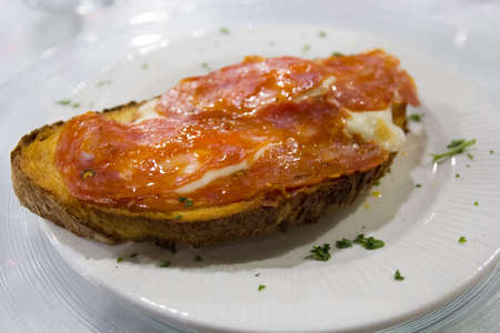 Italian bread (crostino) with mozzarella and spicy salami. Traditional foodの写真素材