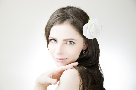 Studio portrait of a young beautiful bride. Professional make-up and hairstyle with flowers.の写真素材
