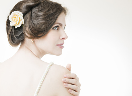 Studio portrait of a young beautiful bride. Professional make-up and hairstyle with flowers.の写真素材