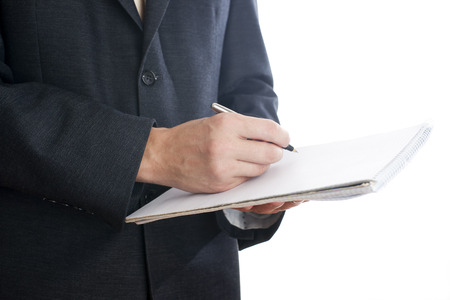 Business man with pen and notepad in suit on white background.の写真素材