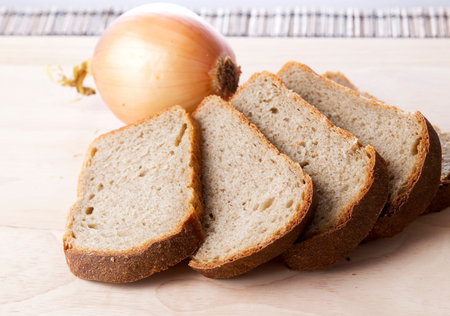 Bread with onions on wooden board.