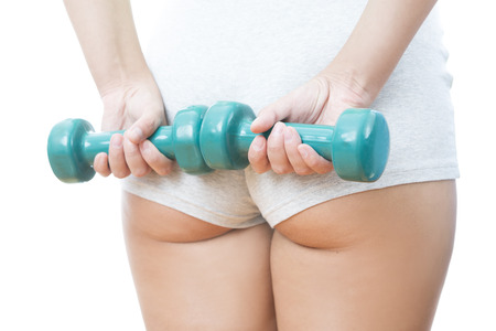 Young woman doing exercises with dumbbells. Isolated on white background.の写真素材