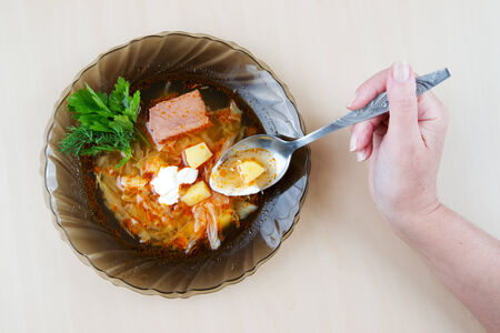 Cabbage soup with meat in a black plateの写真素材