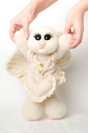 Toy rabbit with heart in his paws. Gift for Valentine's day. Easter Bunny on white background. Handmade.の写真素材