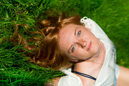 Beautiful young girl resting in meadow.の写真素材