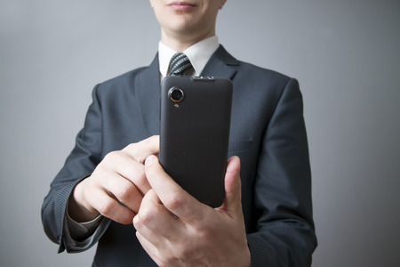 Modern mobile phone in male hand. Businessman using smartphoneの写真素材