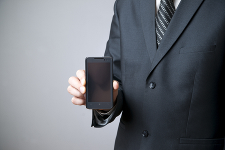 Modern mobile phone in male hand. Businessman using smartphoneの写真素材