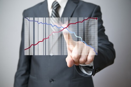 Business concept. Businessman presenting a successful sustainable development on a bar chart on gray background.の写真素材
