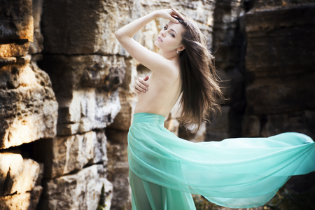 Portrait of a beautiful sexy young woman in a long skirt on natureの写真素材