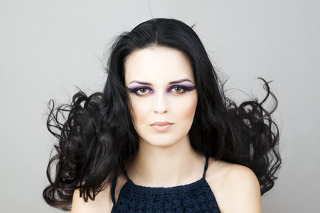 Portrait of a beautiful young woman on a gray background. Professional make-up and hairstyle.の写真素材