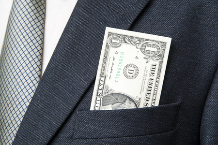 Businessman with money in studio on a gray backgroundの写真素材