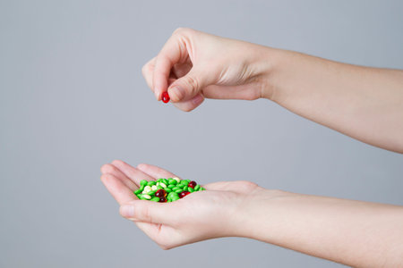 Pills in women hand on gray background.の写真素材