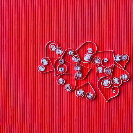 Quilling paper on red cardboard. Background with hearts for Valentine's day.の写真素材