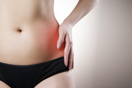 Pain in the left side of the woman. Attack of appendicitis. Red dot.の写真素材