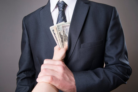 Concept - corruption. Giving a bribe. Money in hand