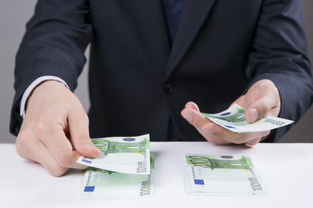 Money in the hands of the men. To count euro on gray backgroundの写真素材
