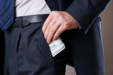 Businessman with money in studio on a gray background