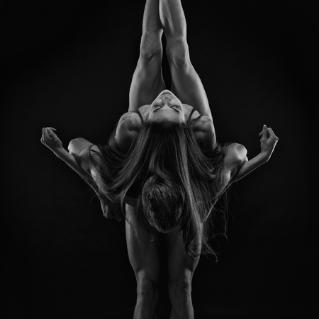 Nude sexy couple. Art photo of young adult man and woman. High contrast black and white muscular naked body on black backgroundの写真素材