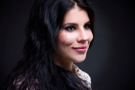 Beautiful young woman portrait. Professional makeup and hairstyle close up on a gray background