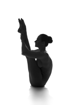 Nude yoga, artistic photos of beautiful sexy body of young woman with perfect figure, isolated on white background, studio shotの写真素材