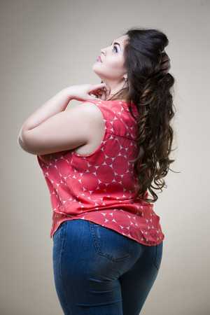 Plus size fashion model in casual clothes, fat woman on beige studio background, overweight female bodyの写真素材