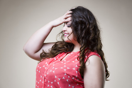 Happy plus size fashion model in casual clothes, fat woman on beige studio background, overweight female bodyの写真素材