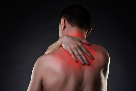 Neck pain, man with backache on black background with red dotsの写真素材