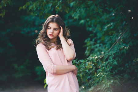 Atmospheric portrait of young beautiful woman, long hair and casual makeup, nature backgroundの写真素材