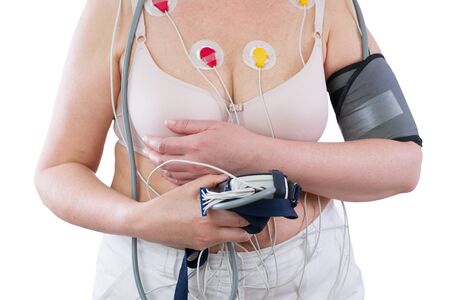 Woman with holter monitor device for daily monitoring of electrocardiogram and blood pressure isolated on white backgroundの写真素材