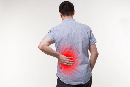Back pain, kidney inflammation, man suffering from backache, painful area highlighted in red