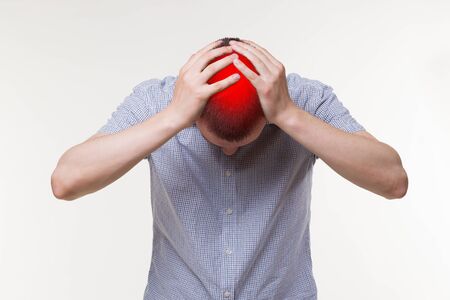 Headache and migraine, man with head pain on white background, painful area highlighted in redの写真素材