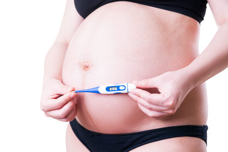 Pregnant woman measures temperature, isolated on white background, studio shot