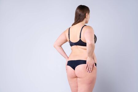 Overweight woman with fat hips and buttocks, obesity female body on gray background, studio shotの写真素材